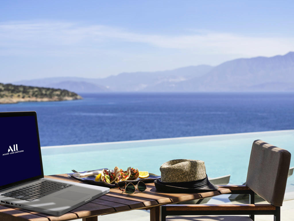 View from an Accor Hotel terrace with an overlook of the open pool and blue sea