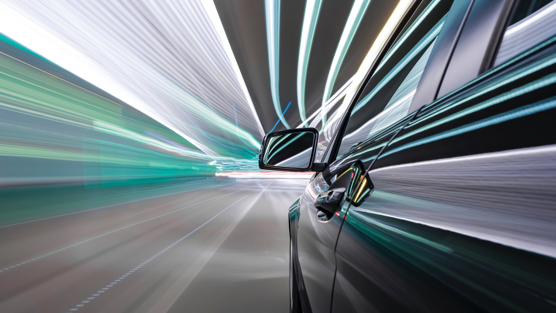 A blurred view of a black car zooming through the streets