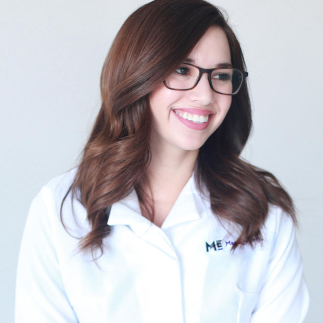 A Massage Envy employee wearing a branded Massage Envy white shirt