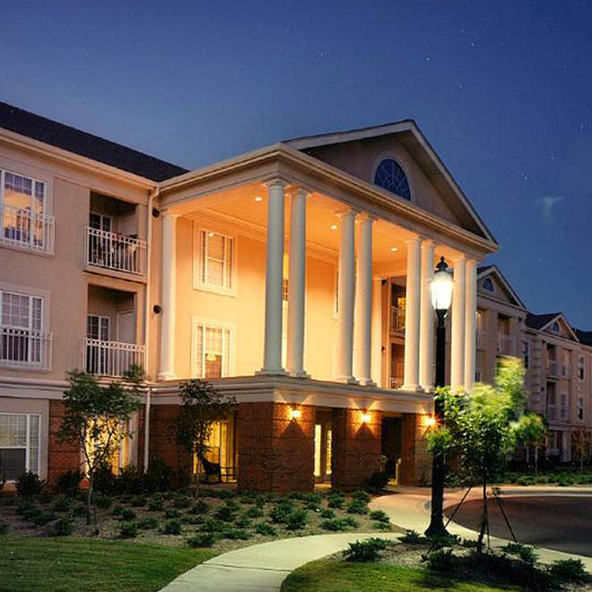 Outside of a Brookdale location, a large building with stunning columns and a manicured lawn.
